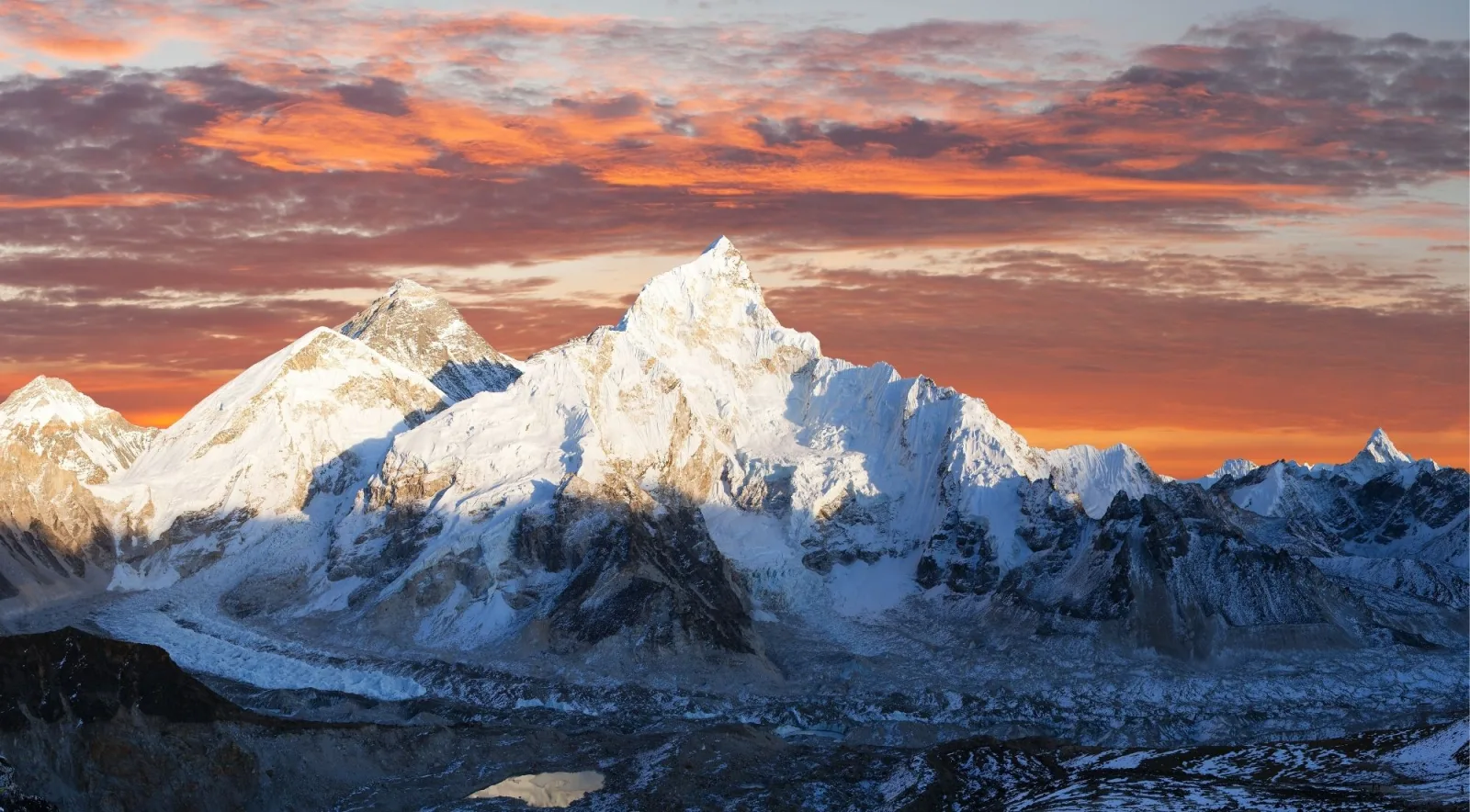 Everest and Nuptse lit orange at dusk above the Khumbu Glacier