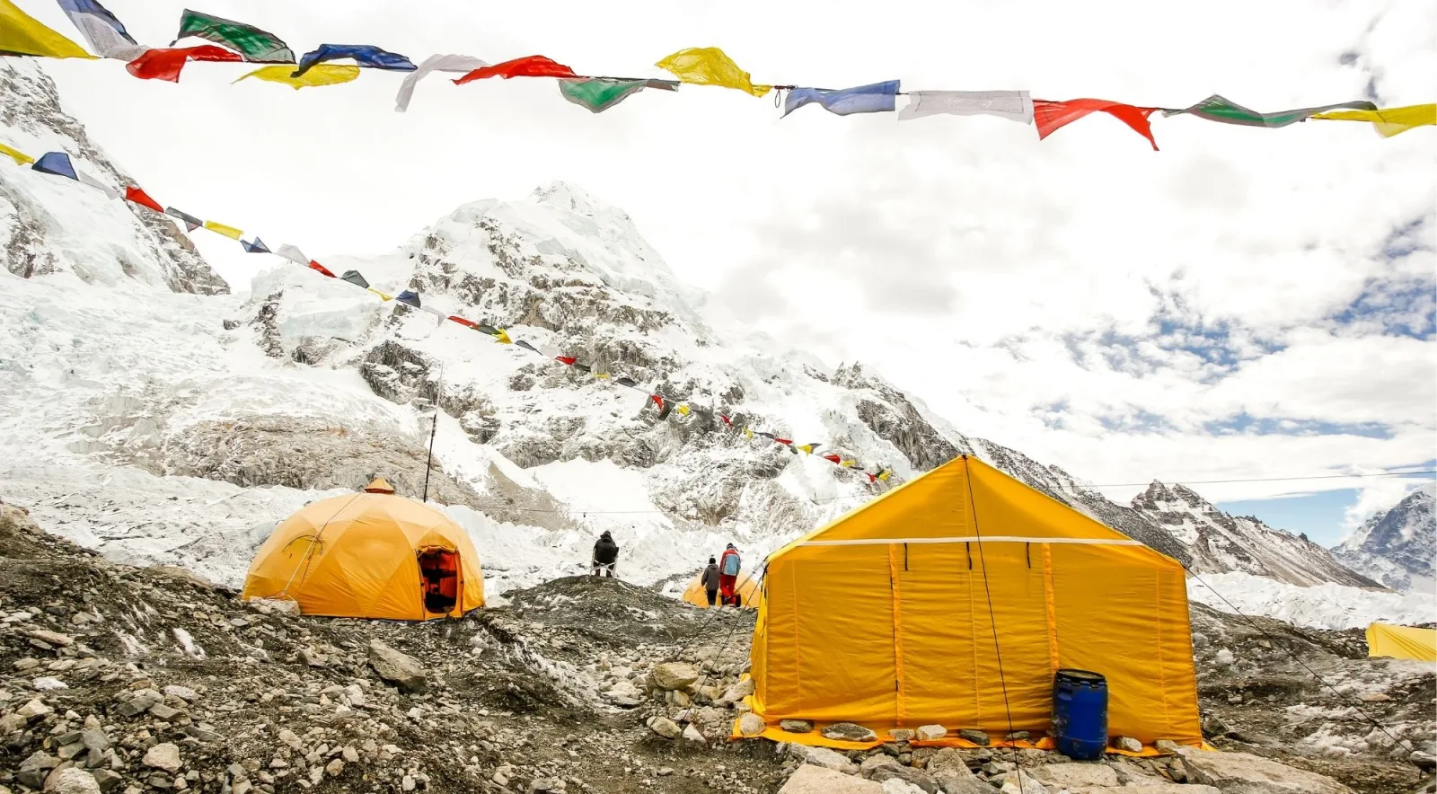Prayer flags strung above tents at Everest Base Camp in misty weather